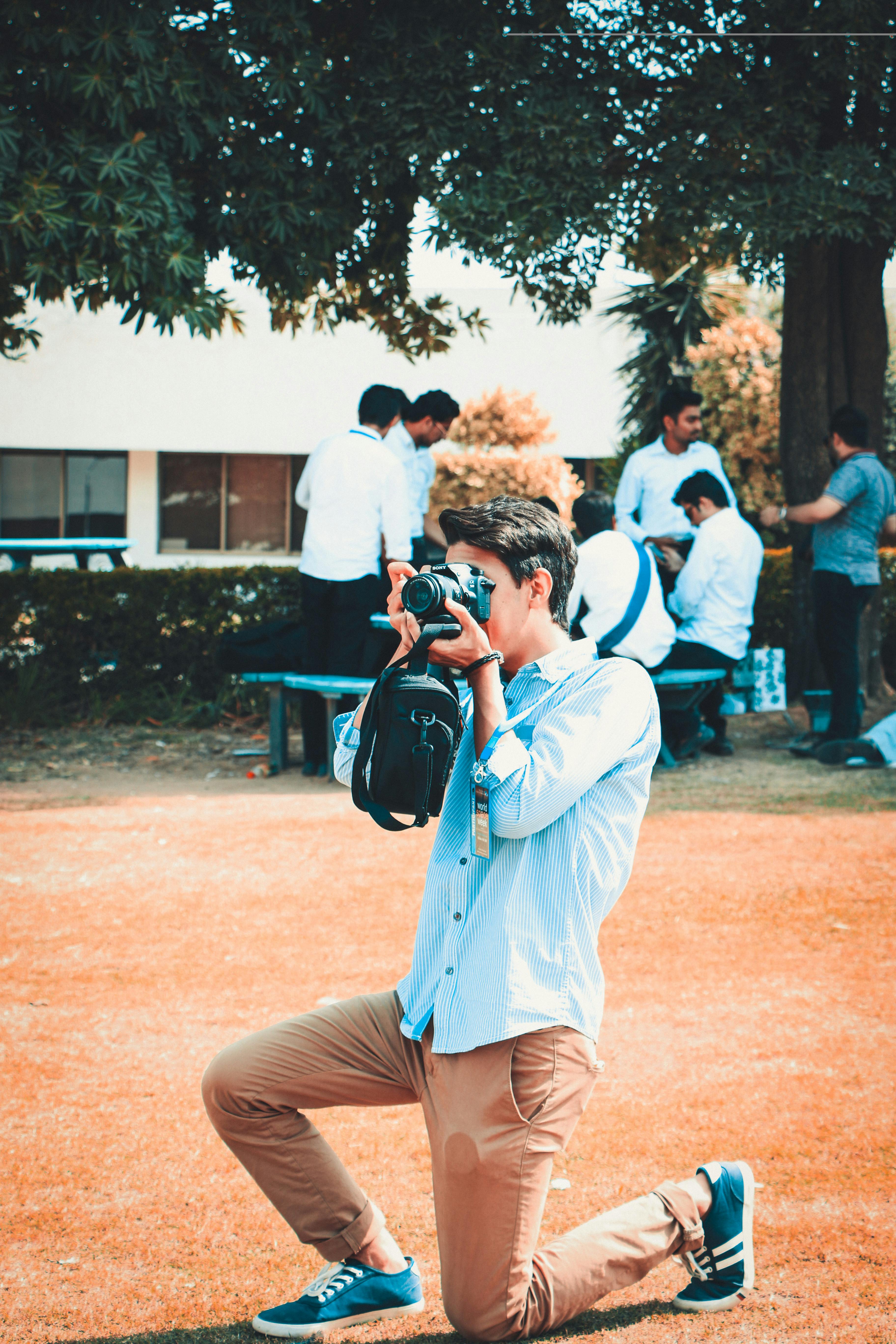 Young Man in Red Jacket Holding Camera · Free Stock Photo