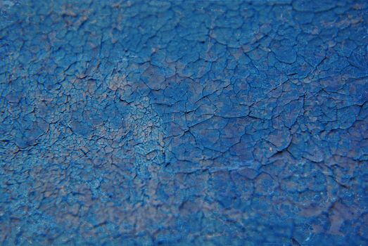 Close-up abstract texture of cracked blue paint with rich details.