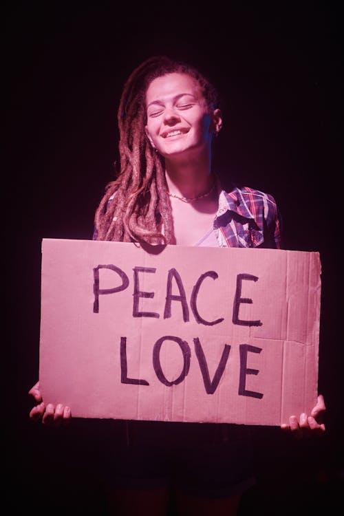 Woman Holding a Peace Love Cardboard