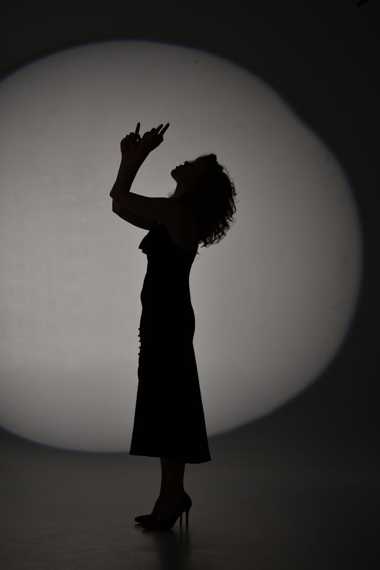 Silhouette Of Woman With Head And Arms Raised Up