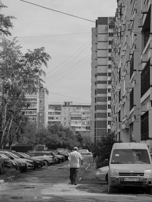 Grayscale Photo of a Person Walking on the Street