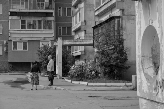 Black and white photo of two people standing near Soviet-era apartments in Yekaterinburg.