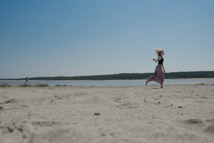 Woman In Black Tank Top Running On The Beach