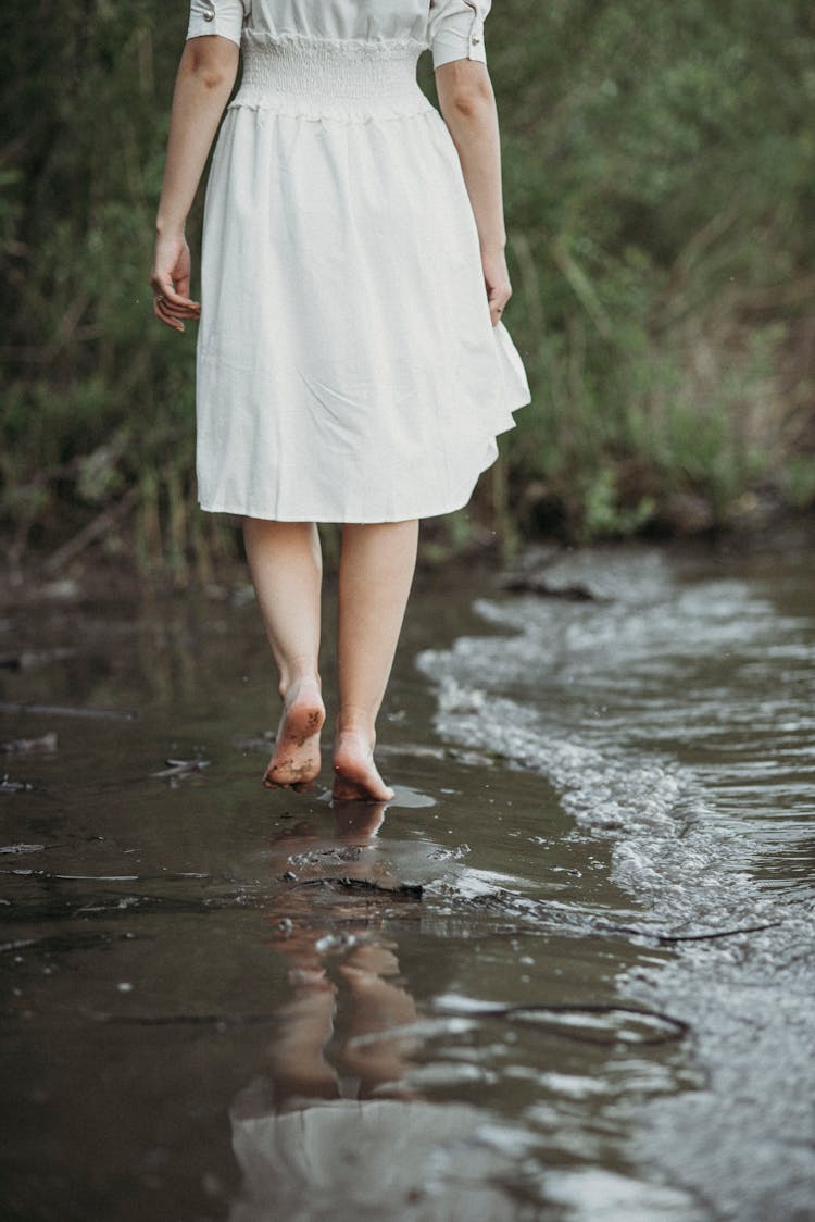 Woman In White Dress Walking Bare Feet On Water