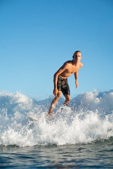 Dynamic shot of a surfer riding a wave in sunny weather, showcasing balance and summertime joy.