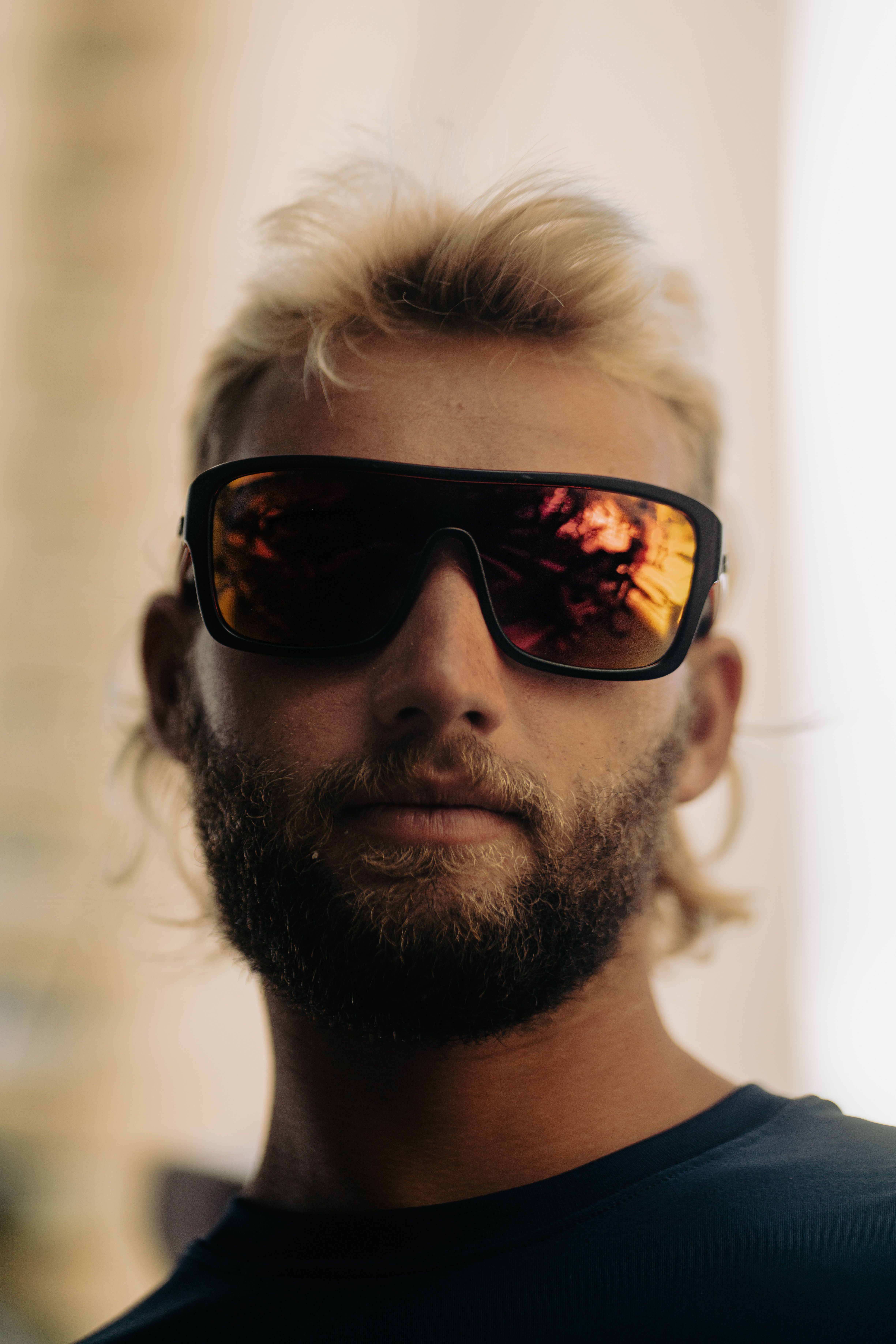 Close-up portrait of a young bearded man wearing stylish sunglasses.