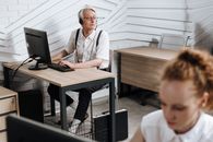 Man in White Button Up Shirt Sitting Beside Brown Wooden Table