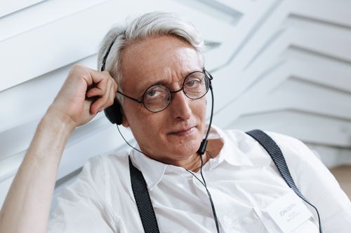 Free Senior man with glasses and headset working in a customer support role, indoors. Stock Photo