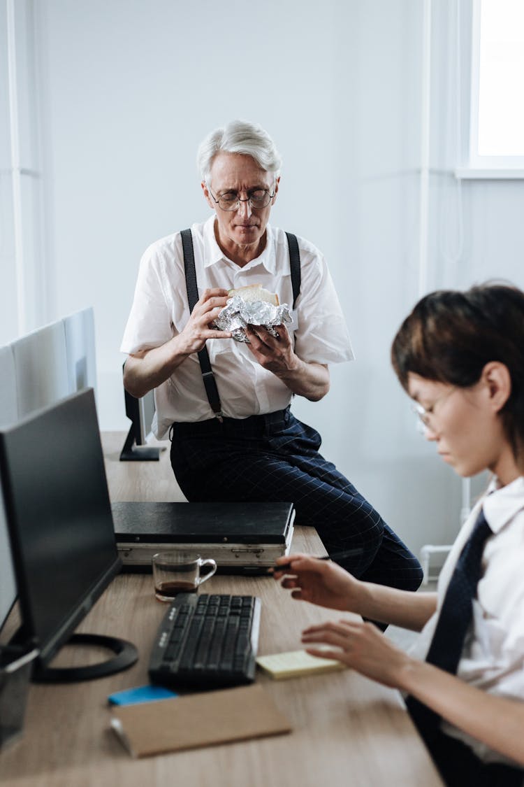 Elderly Man Sitting On The Desk While Eating