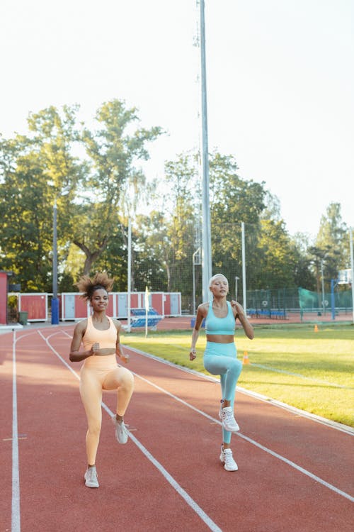 Women Exercising at a Track Field