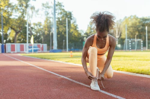 Woman in Activewear Tying Her Shoe