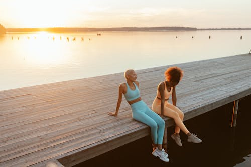 Women Sitting on a Wooden Jetty