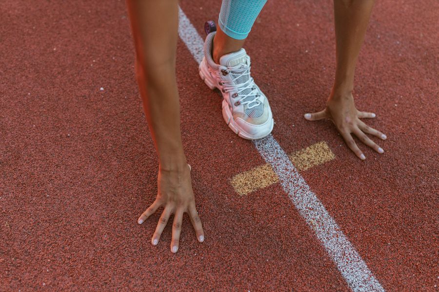 Runner set at the start line on a track, photo by Yaroslav Shuraev on Pexels