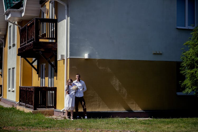 Man And Woman Standing Beside A House