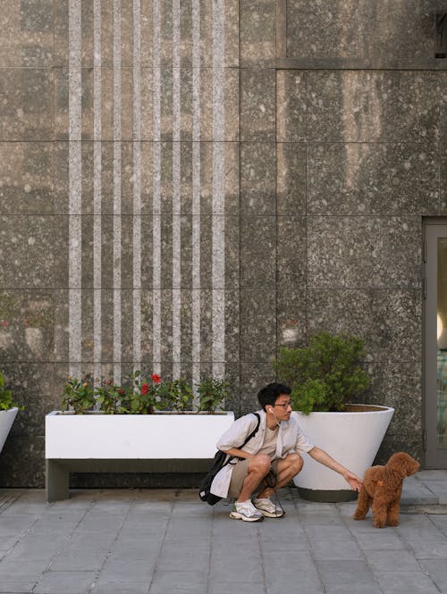 Man Crouching Beside a Dog