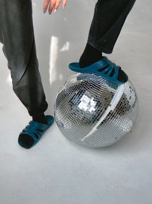 Free A Person Stepping on a Disco Ball Stock Photo