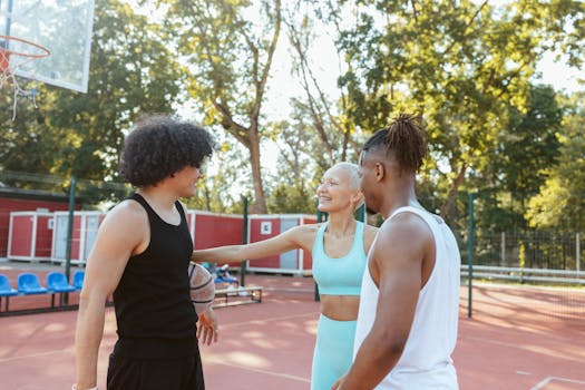 Three friends playing and enjoying a sunny day on the basketball court.