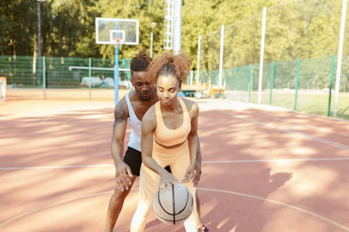 Free Two athletes playing basketball on an outdoor court, perfecting their dribbling skills. Stock Photo