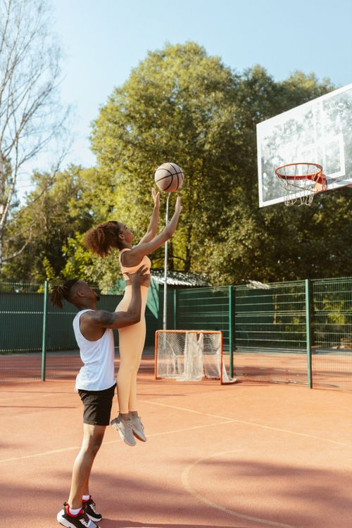 Free Two athletes practice basketball shots outdoors on a sunny day. Stock Photo