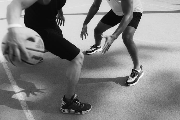 Grayscale Photo Of Two People Playing Basketball