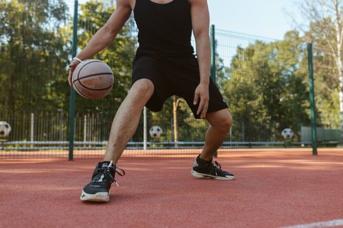 Free Athlete dribbling basketball on outdoor court. Perfect for sports and lifestyle imagery. Stock Photo