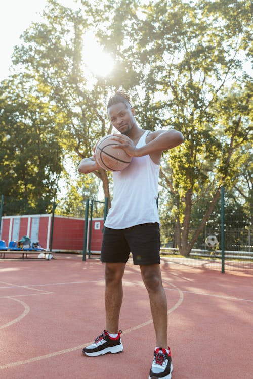 A Man in a White Tank Top Holding a Basketball