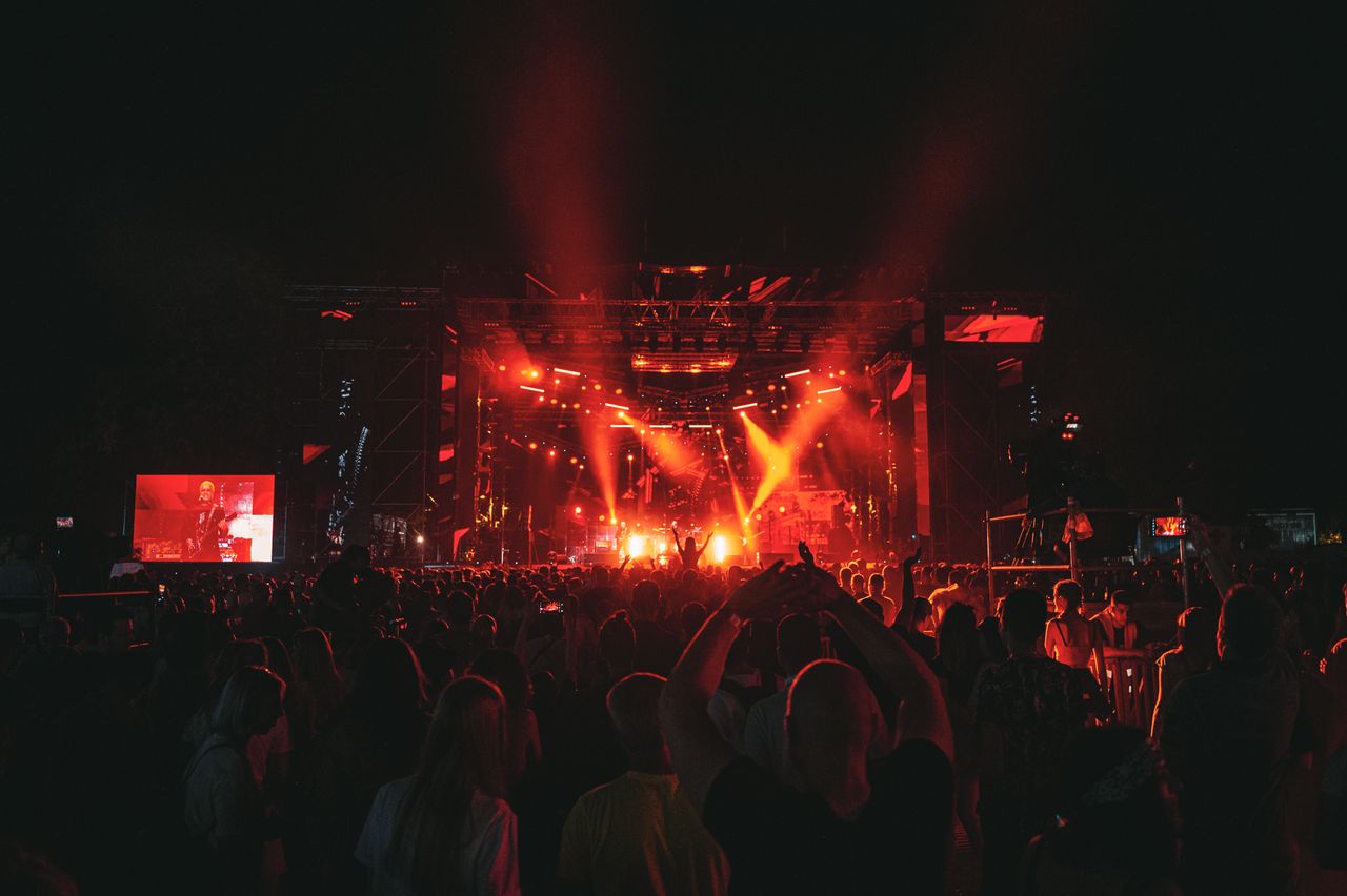 Energetic concert scene with dramatic red lighting
