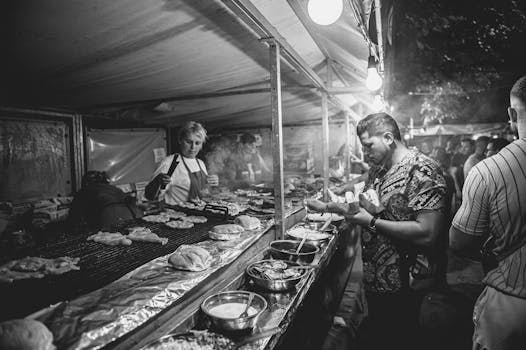 Captivating black and white photo of a bustling food stall at night.