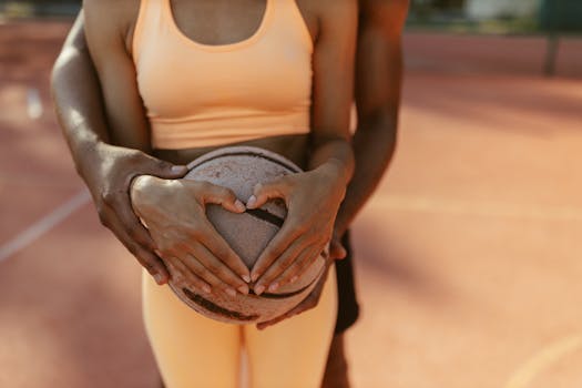 Close-up of a couple holding a basketball, symbolizing teamwork and love outdoors.