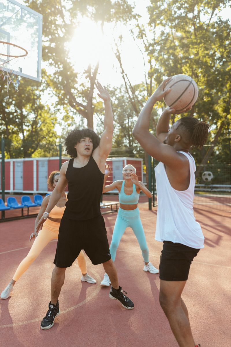 Group playing basketball on an outdoor court at sunset — photo by Yaroslav Shuraev on Pexels
