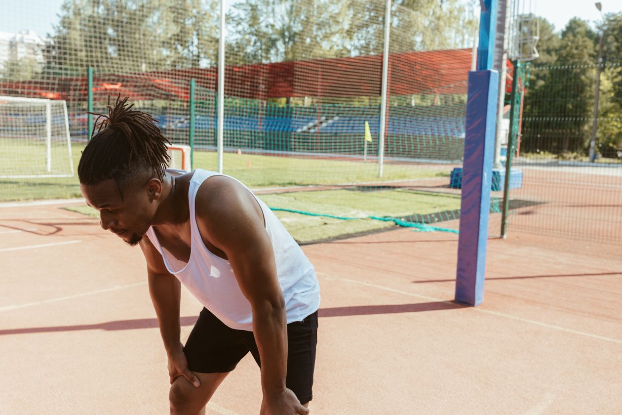 Sportif au repos après l'effort, signe de fatigue musculaire