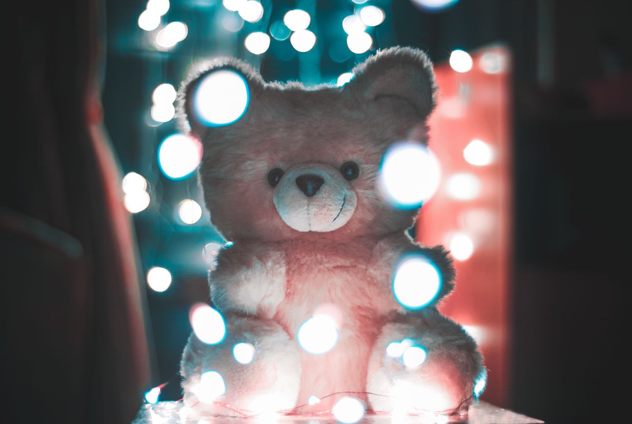 fluffy teddy bear illuminated by warm dreamy bokeh lights in a cozy in