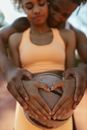 Woman in Orange Tank Top Holding Her Stomach