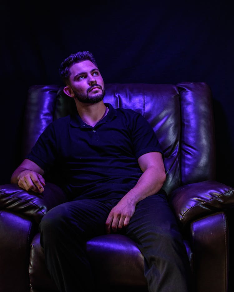 A Man Sitting On A Leather Chair 