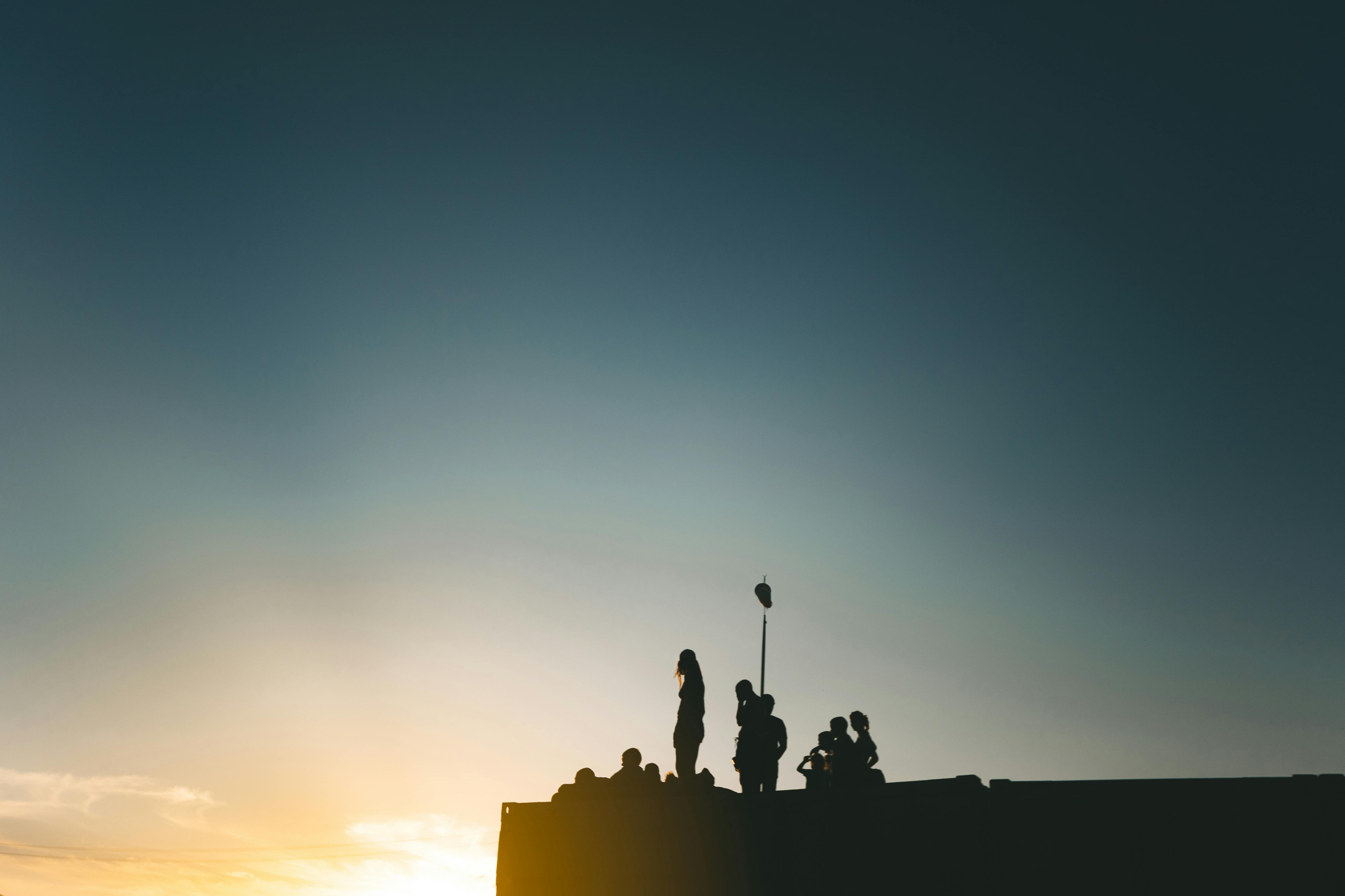 Silhouette of People on a Rooftop at Sunset · Free Stock Photo