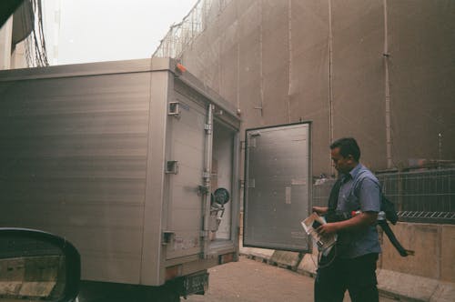 A Man Checking the Back of a Cargo Truck