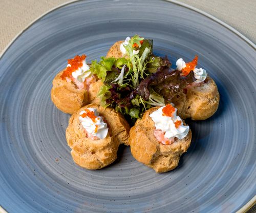 Free Elegant puff pastries topped with caviar and cream cheese, garnished with fresh greens. Stock Photo