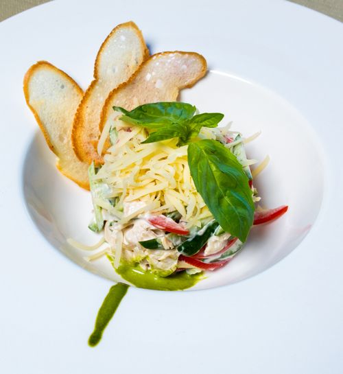 Free Delicious gourmet salad garnished with fresh basil and served with toasted baguette slices. Stock Photo