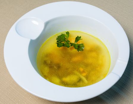 Delicious yellow ginger soup served in a white bowl with parsley garnish.