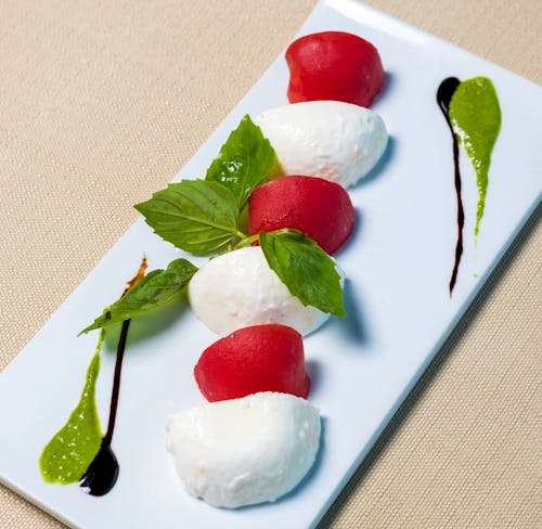 Red and White Round Fruits on White Ceramic Plate