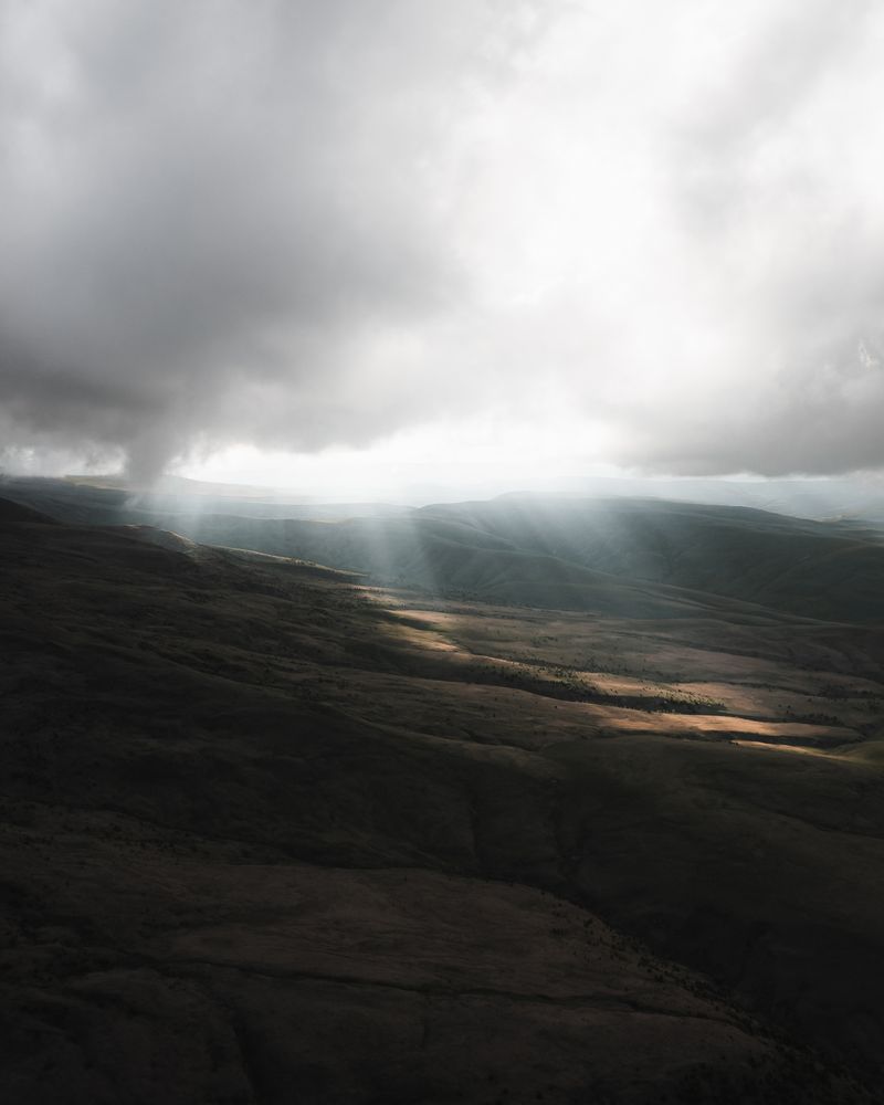 Sun rays breaking through clouds over mountains — Jude Commentary Booklet Five