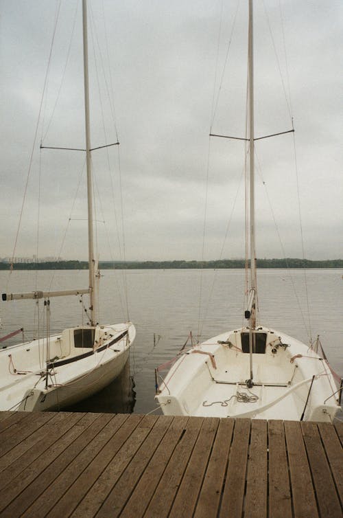 White Sailboats Near Wooden Dock