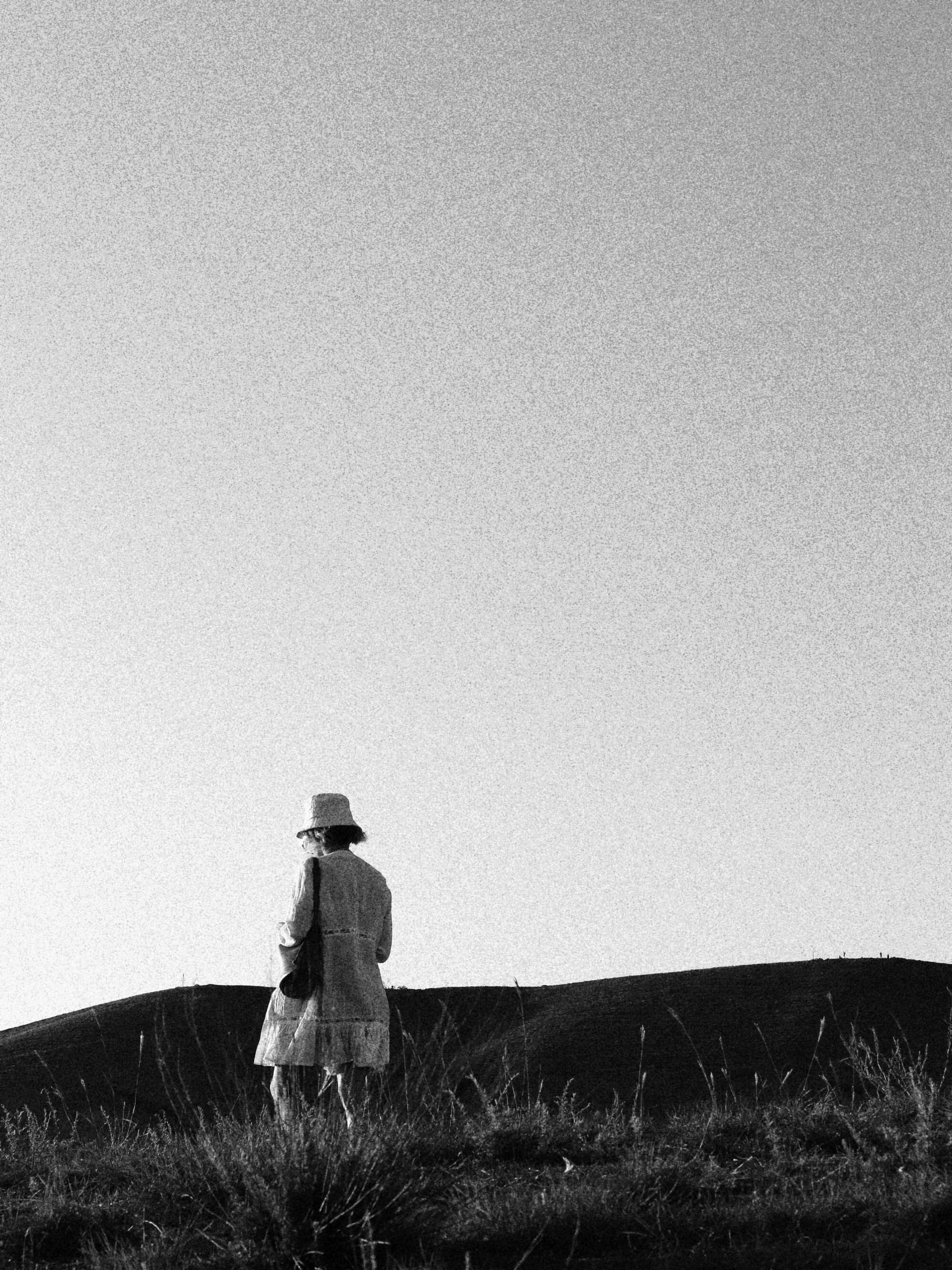 Grayscale Photo of Woman Standing on Grass Field · Free Stock Photo