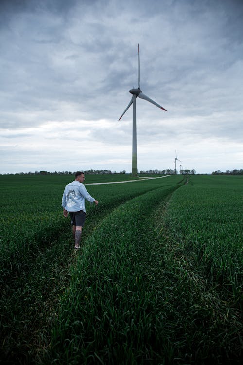 A Man Walking on the Grass Field