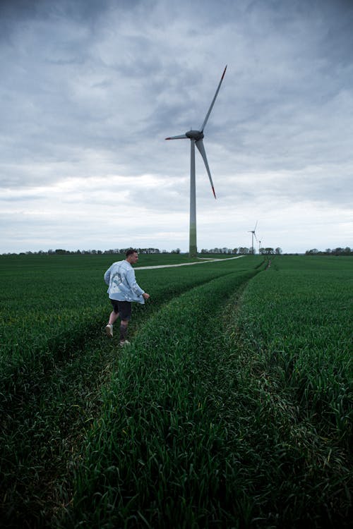 A Man Walking on the Grass Field