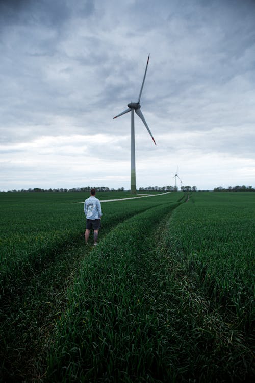 A Man Walking on the Grass Field