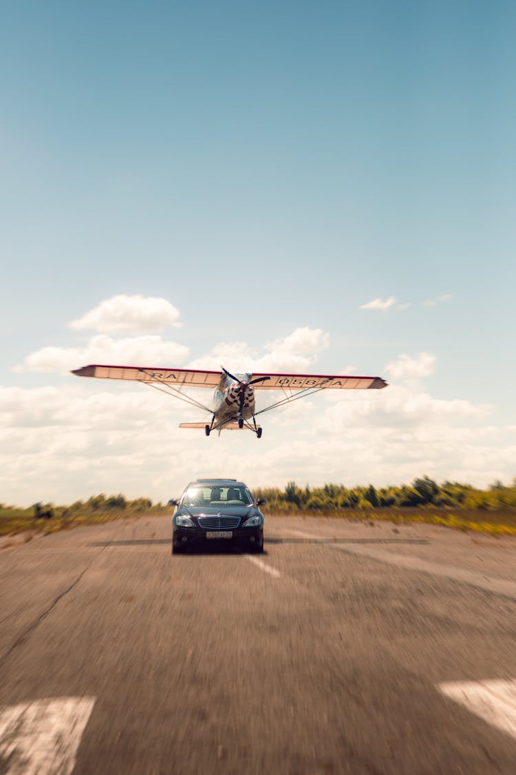 Airplane Flying Over The Black Car