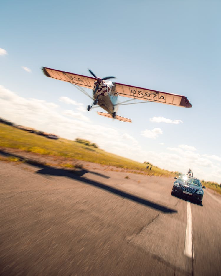 Blurred Motion Of A Plane Flying Over A Car On A Track 