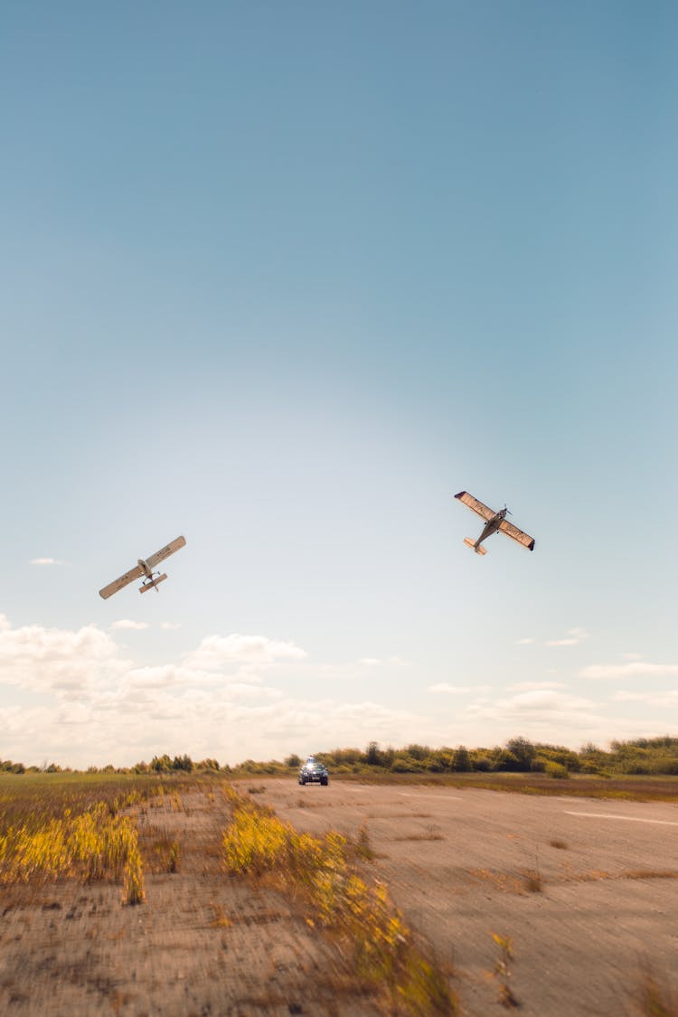 Aiplanes Flying Over Car On Tarmac