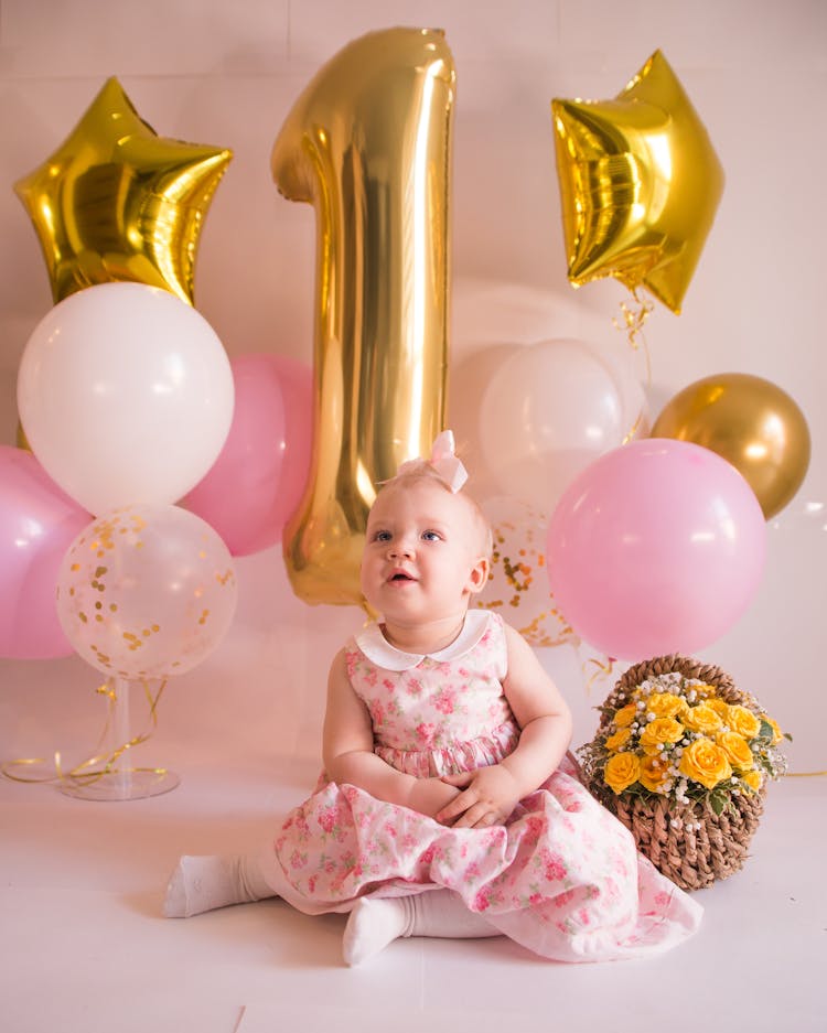 Little Girl Sitting Among Balloons On Her 1st Birthday 